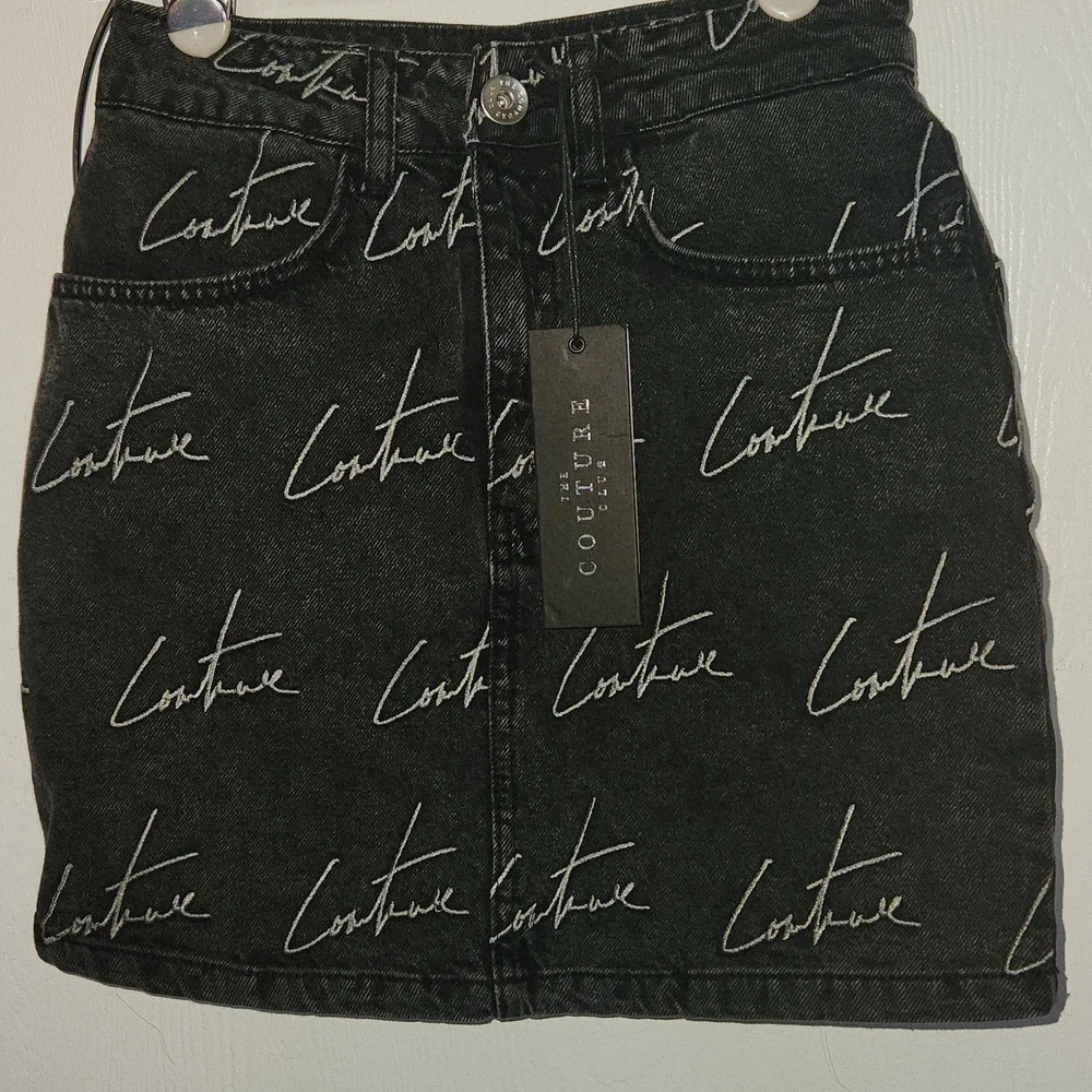 The couture Club Embroidery washed out black Jean Skirt. Size S.